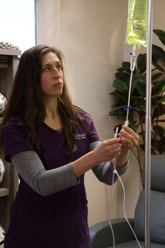 Clinician at UpStream preparing an IV infusion as part of a gut health Omaha care setting focused on whole-person support.