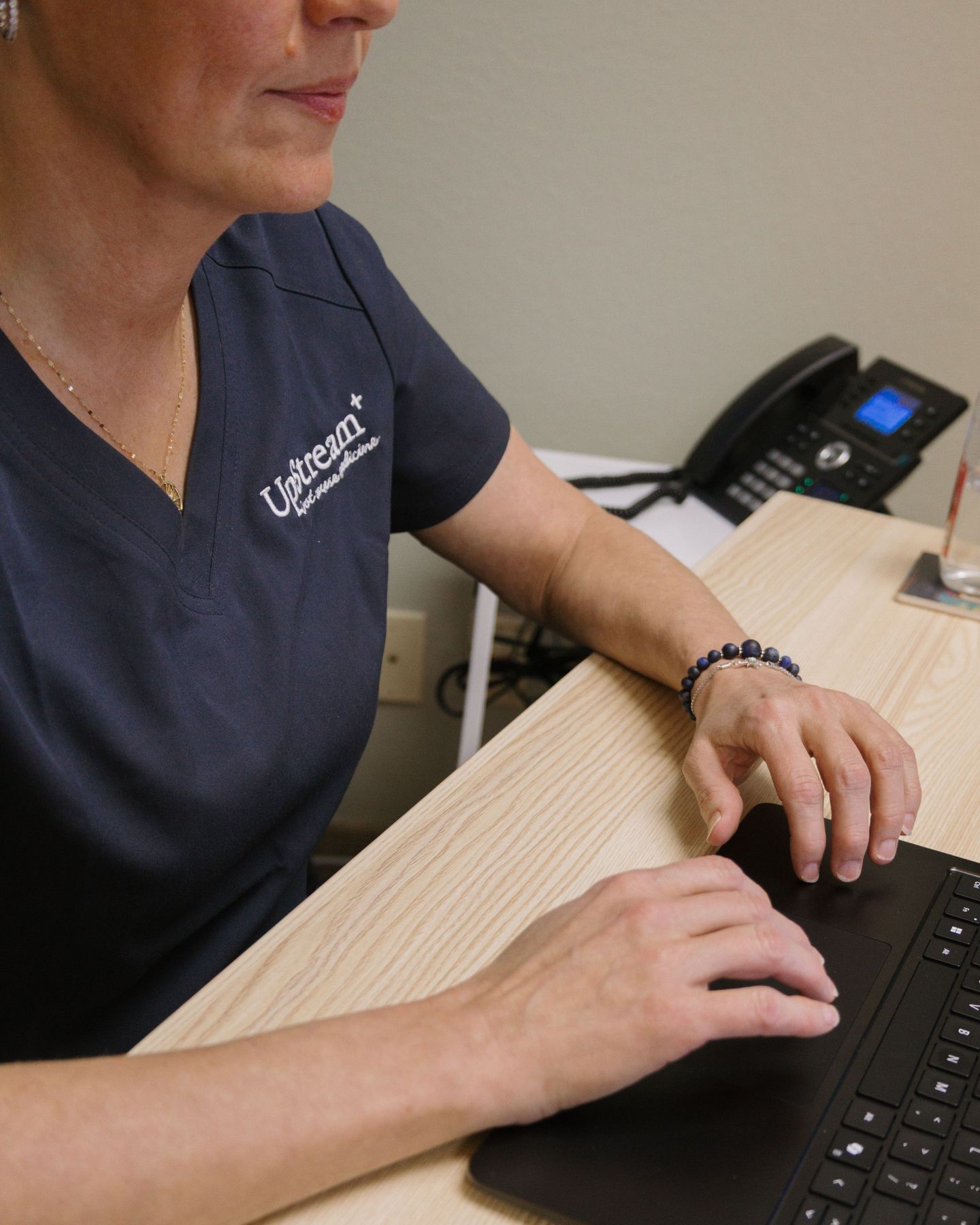 UpStream Root Cause Medicine clinician working at desk, representing integrative medicine Omaha focused on personalized, coordinated care.