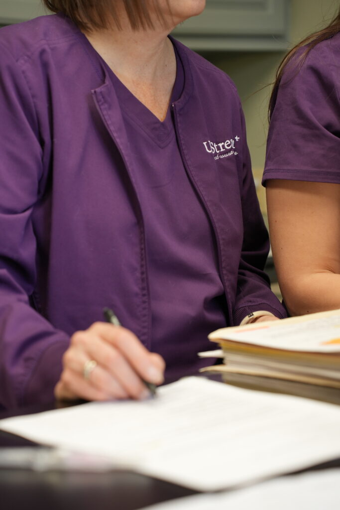 Provider reviewing patient records during a systems based functional medicine consultation in Omaha, focused on identifying root causes across interconnected health systems.