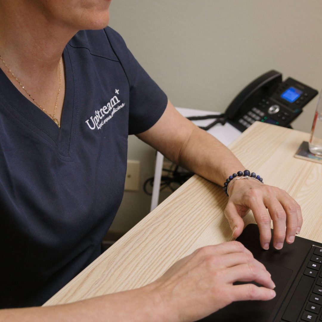 UpStream Root Cause Medicine clinician working at desk, representing integrative medicine Omaha focused on personalized, coordinated care.