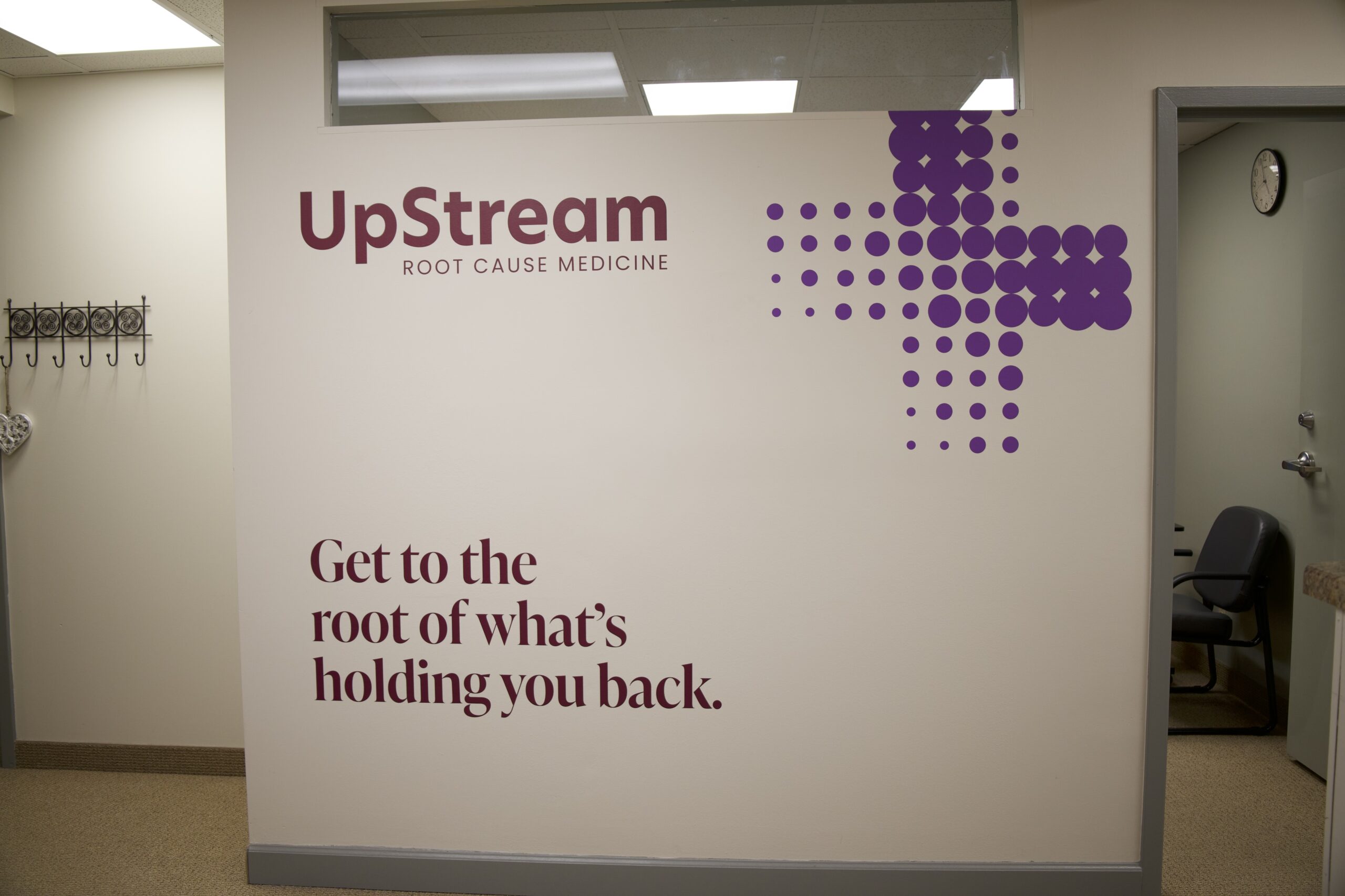 Interior wall signage at UpStream Root Cause Medicine in Omaha, a clinic focused on root-cause care for fatigue in Omaha.