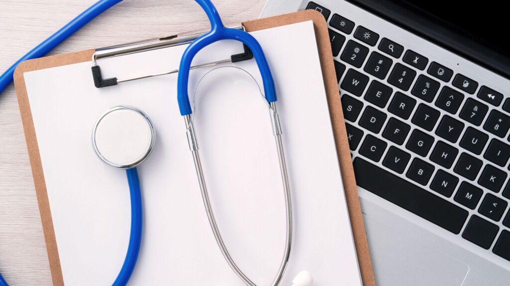 Stethoscope and clipboard on a laptop representing gut health functional medicine Omaha evaluation.