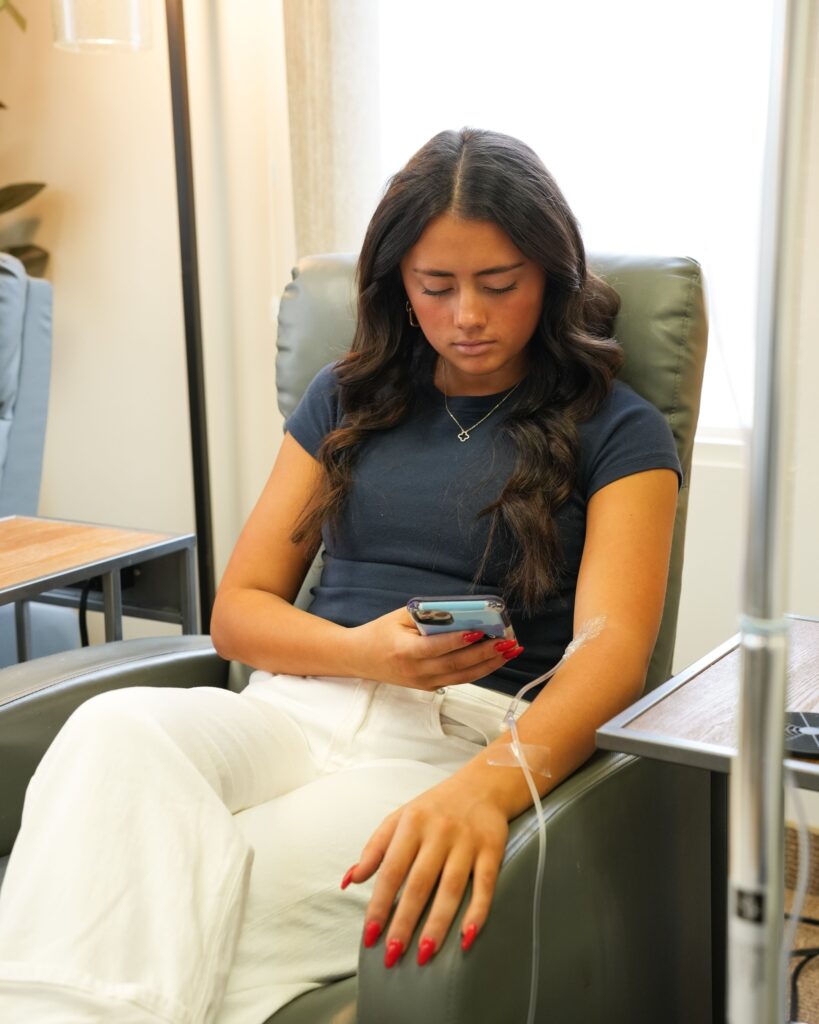 Patient receiving IV therapy while relaxing during treatment for low stress tolerance and improving recovery and stress resilience