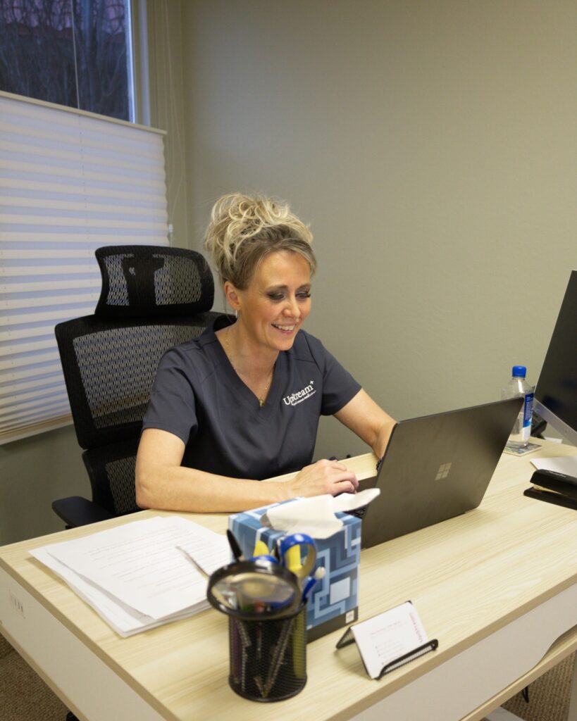 Healthcare provider at Upstream Root Cause Medicine in Omaha consulting with a patient on peptide therapy and personalized wellness plan